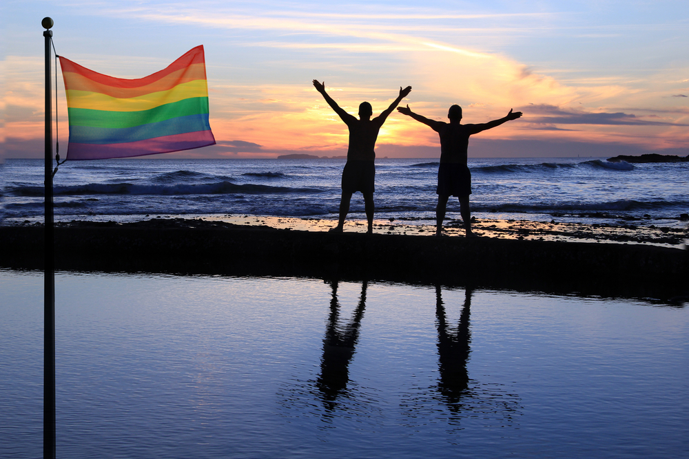 Group of LGBTQ+ travelers and locals enjoying sunset together on Sri Lankan beach